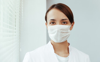 Closeup portrait of a doctor girl. Doctor in medical mask