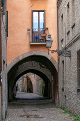 Fototapeta na wymiar vertical photo of an arched passage in a narrow Italian street