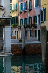 Fototapeta na wymiar vertical photo of colorful buildings standing on the banks of the Venetian canal