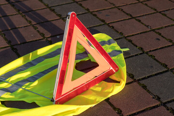 Red triangle warning sign and yellow safety vest