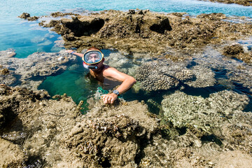 Man in the mask for posing against the backdrop of the beautiful sea landscape and corall reef