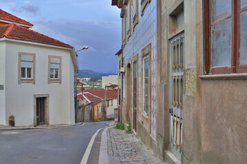 A small, Portuguese street with old houses.
Colorful landscape of a European residential street.
