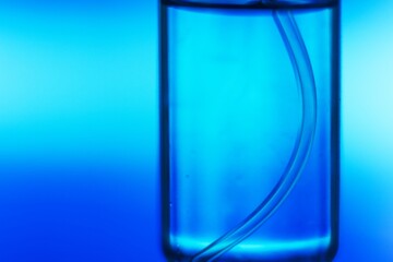 Blurred Close up of glass bottle with of blue medicine or vaccine photographed