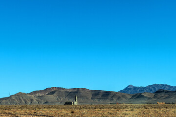 Fototapeta na wymiar Mountain view with distant mosque in High Atlas, Morocco 