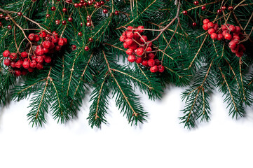 Spruce branches with rowan berries and Christmas decorations isolated on white background. Design template for New Year and Christmas.