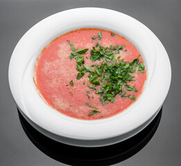 Tomato, red pepper soup, sauce with olive oil, rosemary and smoked paprika on a wooden background.