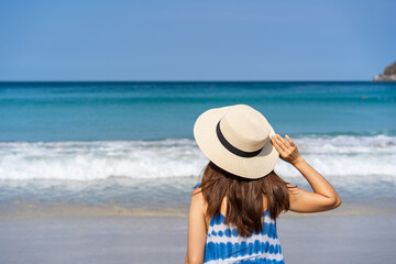 Fototapeta na wymiar Young woman traveler enjoying a summer vacation at tropical sand beach