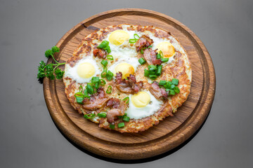 Plate with fried eggs, bacon, tomato and potato griddle cakes close up