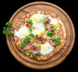 Plate with fried eggs, bacon, tomato and potato griddle cakes close up
