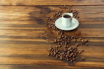 White coffee cup and coffee beans on old wooden background.