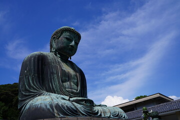 Obraz premium The Great Buddha of Kamakura is an outdoor bronze statue of Amida Buddha under blue sky located on the grounds of Kotoku-in Temple in Kanagawa Prefecture Japan. Kamakura Daibutsu Statue.