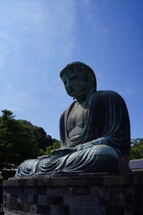 Obraz premium The Great Buddha of Kamakura is an outdoor bronze statue of Amida Buddha under blue sky located on the grounds of Kotoku-in Temple in Kanagawa Prefecture Japan. Kamakura Daibutsu Statue.