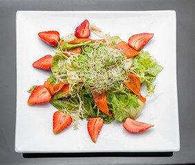 Strawberry, avocado, lettuce salad with cashew nuts on plate
