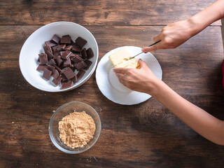 Chocolate, biscuits and butter set on a table ready to be used for baking a cake, no people