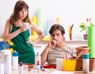 Couple decorating pots in workshop during class