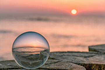 traumhafter Sonnenaufgang an der Ostsee durch eine Glaskugel fotografiert