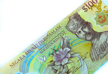 Image of isolated colorful $100 brunei dollar banknotes over white. Focus on banknote.