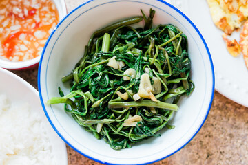 Rau muong is a sauteed Vietnamese dish made with water spinach, garlic, and fish sauce.  A healthy side/snack that is no carb and paleo friendly.