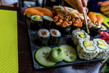 Eating with chopstick. Sushi set restaurant. Black background.