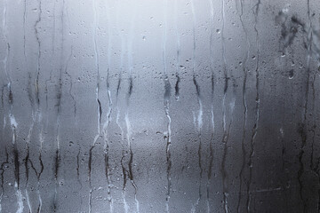 Wet window background. Drops of condensate on the sweaty glass. Cold foggy glass