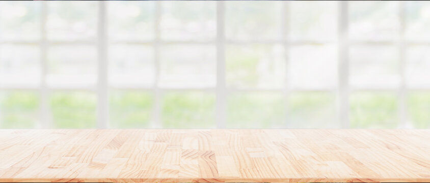 Wood table top on blur kitchen window background, can be used for display or montage your products or foods