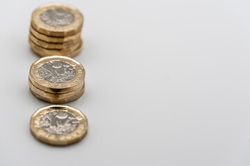 Stacks of UK Sterling pound coins on a white background
