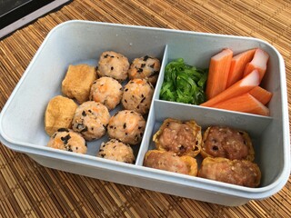 Lunch box includes Tuna Salmon Sushi ball, seaweed salad and tofu mixed pork meatball.