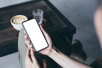 cell phone mockup image blank white screen.woman hand holding texting using mobile on desk at coffee shop.background empty space for advertise.work people contact marketing business,technology