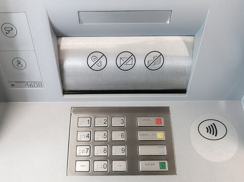 Close-up of an ATM keyboard and a compartment for receiving and issuing banknotes. Safe banking, entering a PIN code, receiving and depositing cash. 