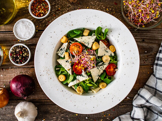 Fresh salad - blue cheese and vegetables on wooden table
