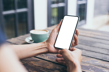 cell phone mockup image blank white screen.woman hand holding texting using mobile on desk at coffee shop.background empty space for advertise.work people contact marketing business,technology