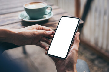 cell phone mockup image blank white screen.woman hand holding texting using mobile on desk at coffee shop.background empty space for advertise.work people contact marketing business,technology