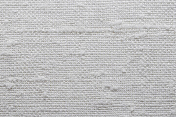 Texture of an old natural linen fabric with many defects. White textile material for background....
