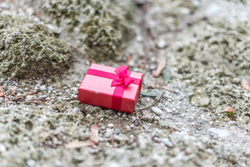 Rotes Geschenkspaket liegt auf Felsen