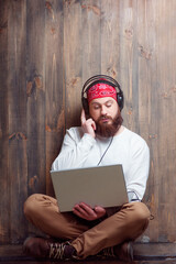 bearded man in headphones using laptop