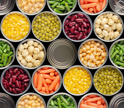Seamless food background made of opened canned chickpeas, green sprouts, carrots, corn, peas, beans and mushrooms on black background