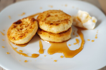 cottage cheese pancakes with honey and sour cream, delicious and healthy Breakfast, beautiful early Sunny morning, healthy food concept