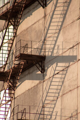 A repeating staircase with a shadow from it on a concrete color building