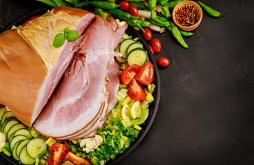 Whole cutted ham with vegetables and herbs.