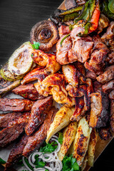 Assorted Mixed different grilled meat with vegetables on table