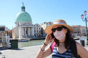 woman with surgical mask while talking on the phone in Venice du