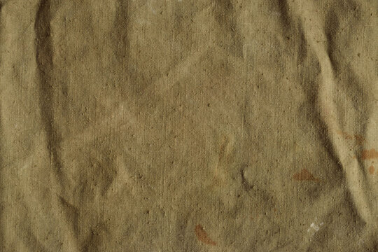 Old, crumpled and dirty khaki color tarpaulin, detailed texture. Fabric of  a vintage army military or travel backpack for background. Worn natural sail  cloth material with stains foto de Stock | Adobe