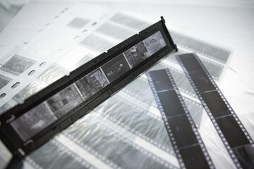 Film photography. 35mm and medium format film. Holding a film strip, putting it inside a scanner frame, preparing for scanning.