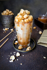 Sweet and salty caramel popcorn milkshake, caramel, milk, vintage dark background, drink