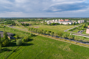 Fototapeta na wymiar Aerial view of the city at sunny summer day. Beautiful green city park with blooming apple trees.
