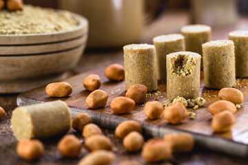peanut jam on rustic table with pieces of peanut around. Brazilian paçoca.