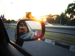 The man use camera to take the photo sunset on the car. Backlight photography.