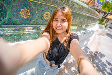 Fototapeta na wymiar Cute Asian woman. She is taking a selfie happily