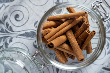 Cinnamon sticks on a table inside a glass jar