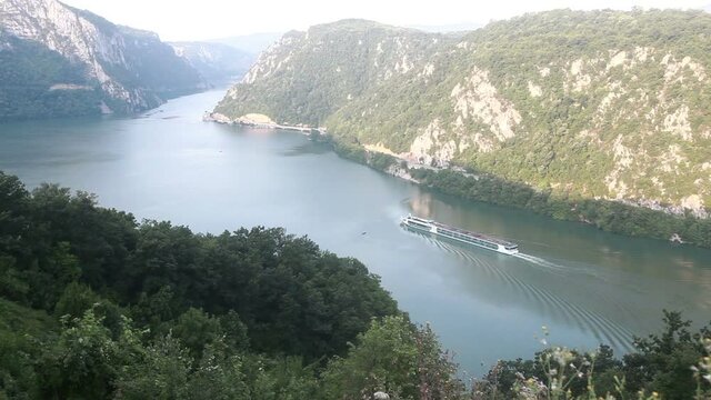  Danube river summer landscape. The cruiser ship passes through the part of the gorge on the Danube between Serbia and Romania, also known as the Iron Gate.